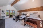 The upper level master bedroom with king bed, seating area with gas fireplace, private deck and en-suite bathroom